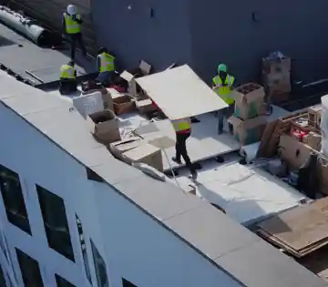 Aerial view of a rooftop commercial turf installation with crew carrying turf panels